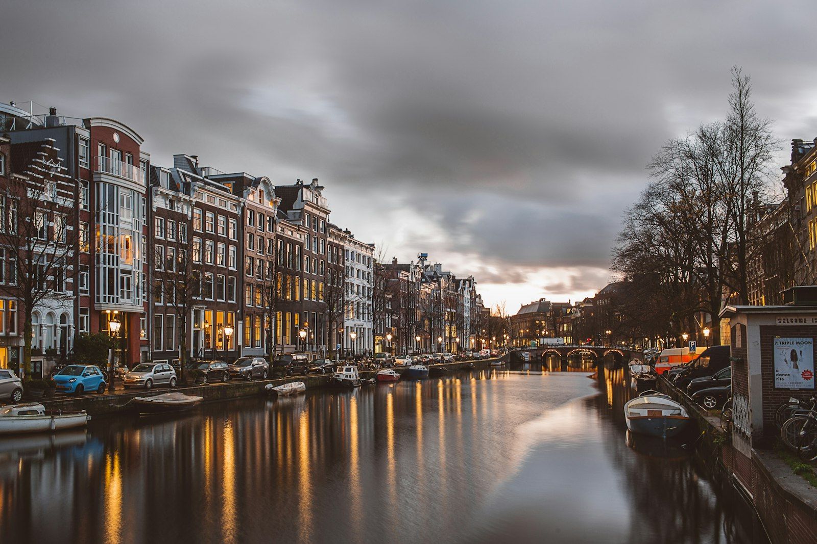 Herenhuizen aan een Amsterdamse gracht in de avondschemering.
