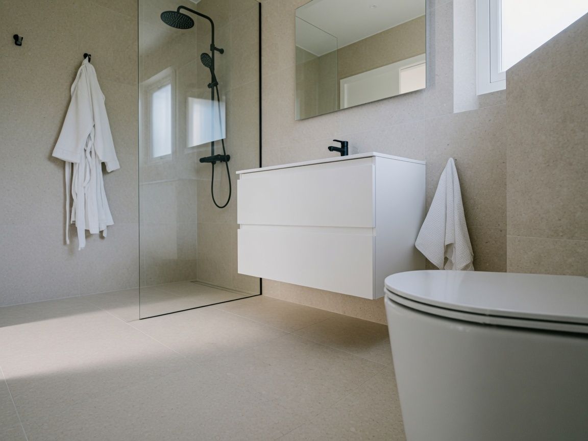 Sfeerbeeld: zithoek met fauteuil en bijzettafel in een lichte woonkamer.