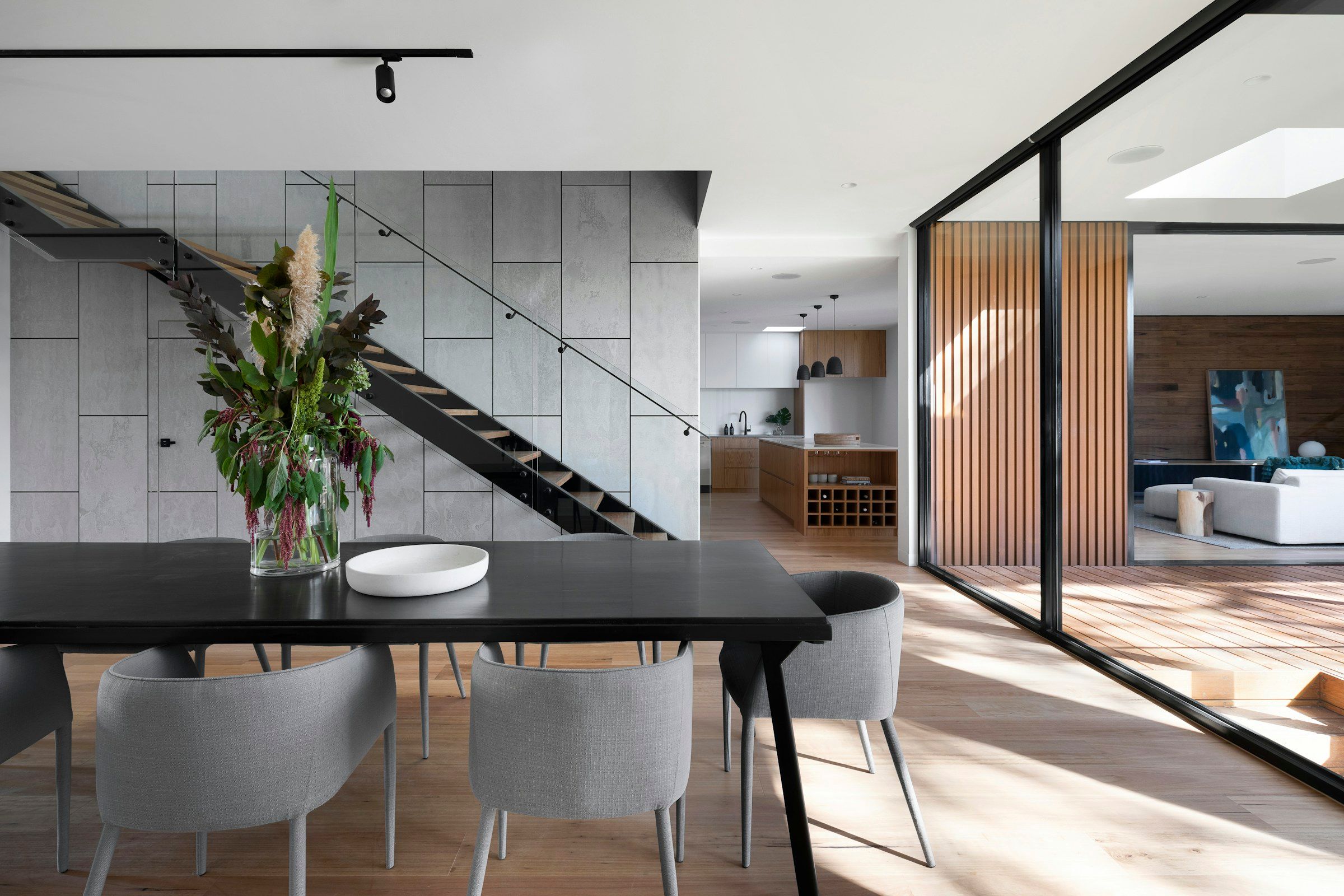 Eethoek in een modern interieur met lichte houten vloer, glaswand en maatwerk.