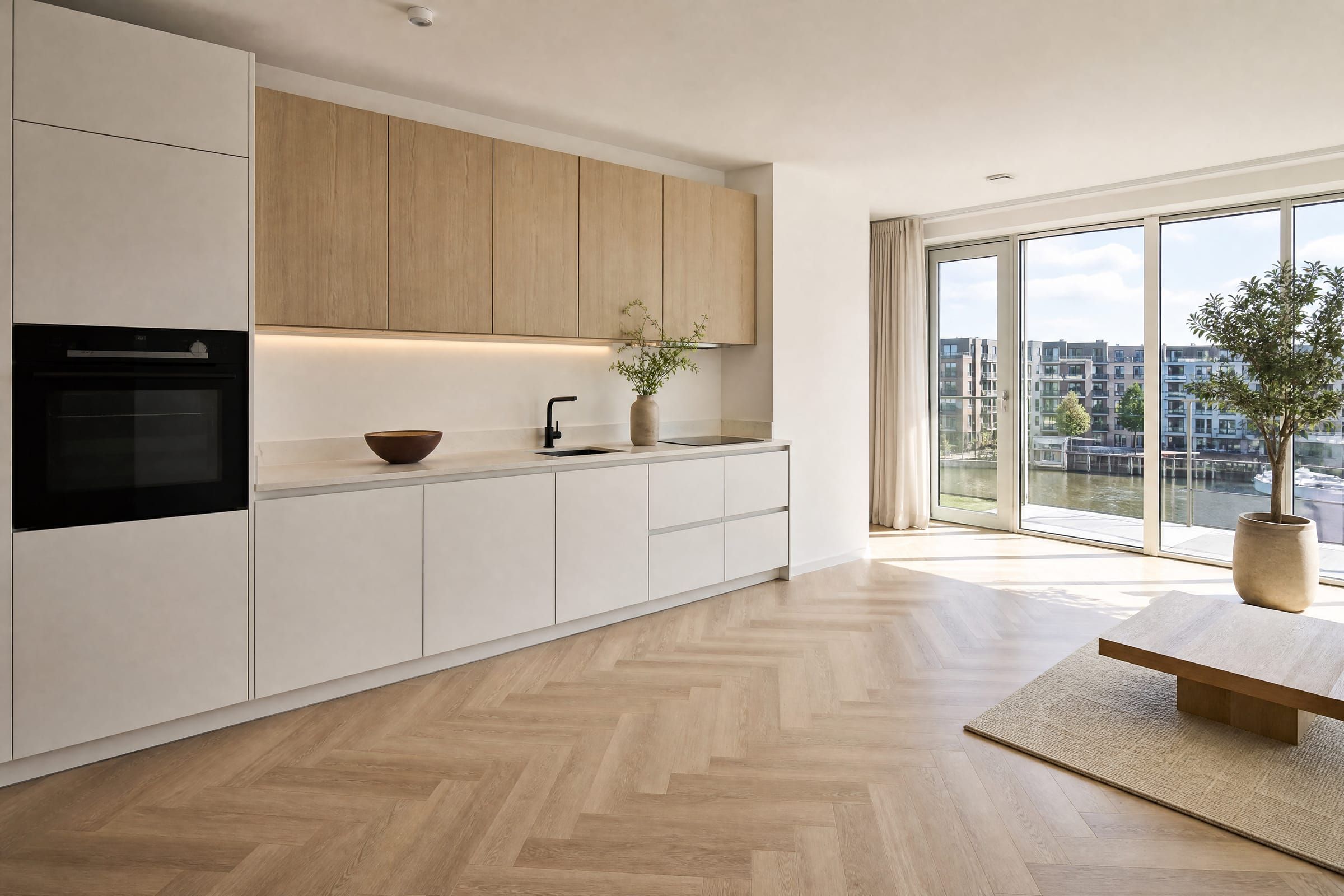 Lichte keuken met witte en eikenhouten fronten en visgraatvloer in een modern appartement.