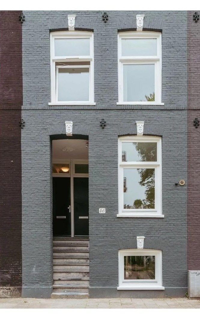Entree van een gerenoveerd Amsterdams herenhuis met witte kozijnen.